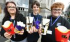 Ryan Bannerman, 15 and Lucas Mackenzie, 14 have launched a charity appeal for people to donate their McDonald's Monopoly Tokens, which give away prizes, including free food and drink. They will donate all the tokens they collect to The Care Hub Aberdeen, which is a local cause which provides support to the vulnerable and homeless. Pictured are Lucas (centre) and Ryan with Michelle Houghton, co-founder of the Care Hub Aberdeen.  Picture by Chris Sumner/DCT