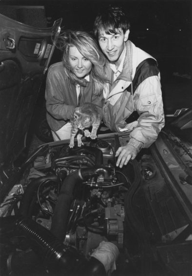 1989: Cat lovers Sam Toher and Dave Young look in the engine compartment of their car to see where their stowaway kitten Pooh had hidden.