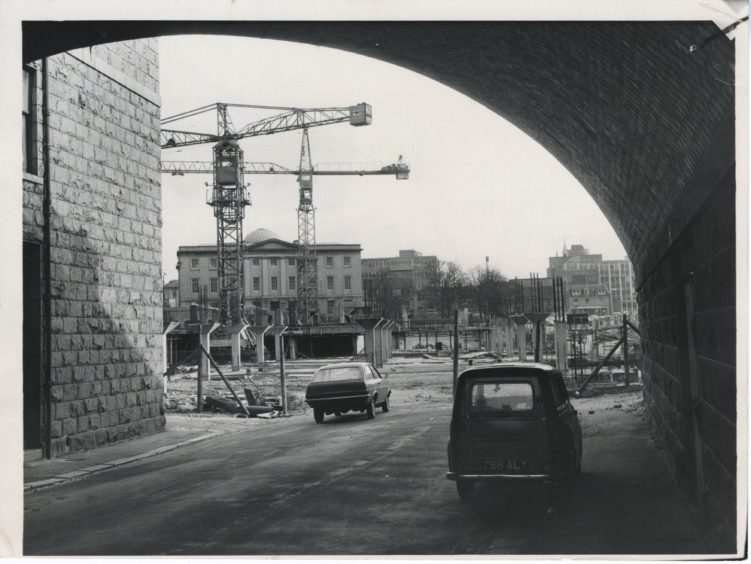 1972: It is just a year this month since work began on the £1,000,000 Denburn redevelopment plan which will transform the heart of Aberdeen. Our picture, taken from under the bridge that carries Rosemount Viaduct over Jack's Brae, shows the first stages of the new covered car park for 600 cars. This view of the old Royal Infirmary buildings will disappear for good when the car park - it is to have the town's first health centre built over it - is completed