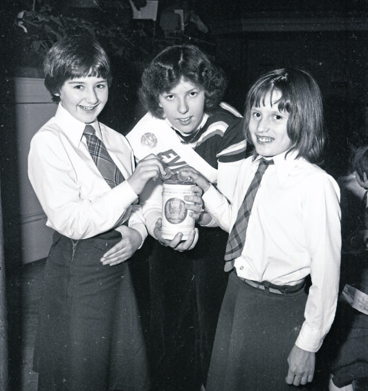 1977: Youngsters popping coins into a collection tin doing the rounds at the concert gathering