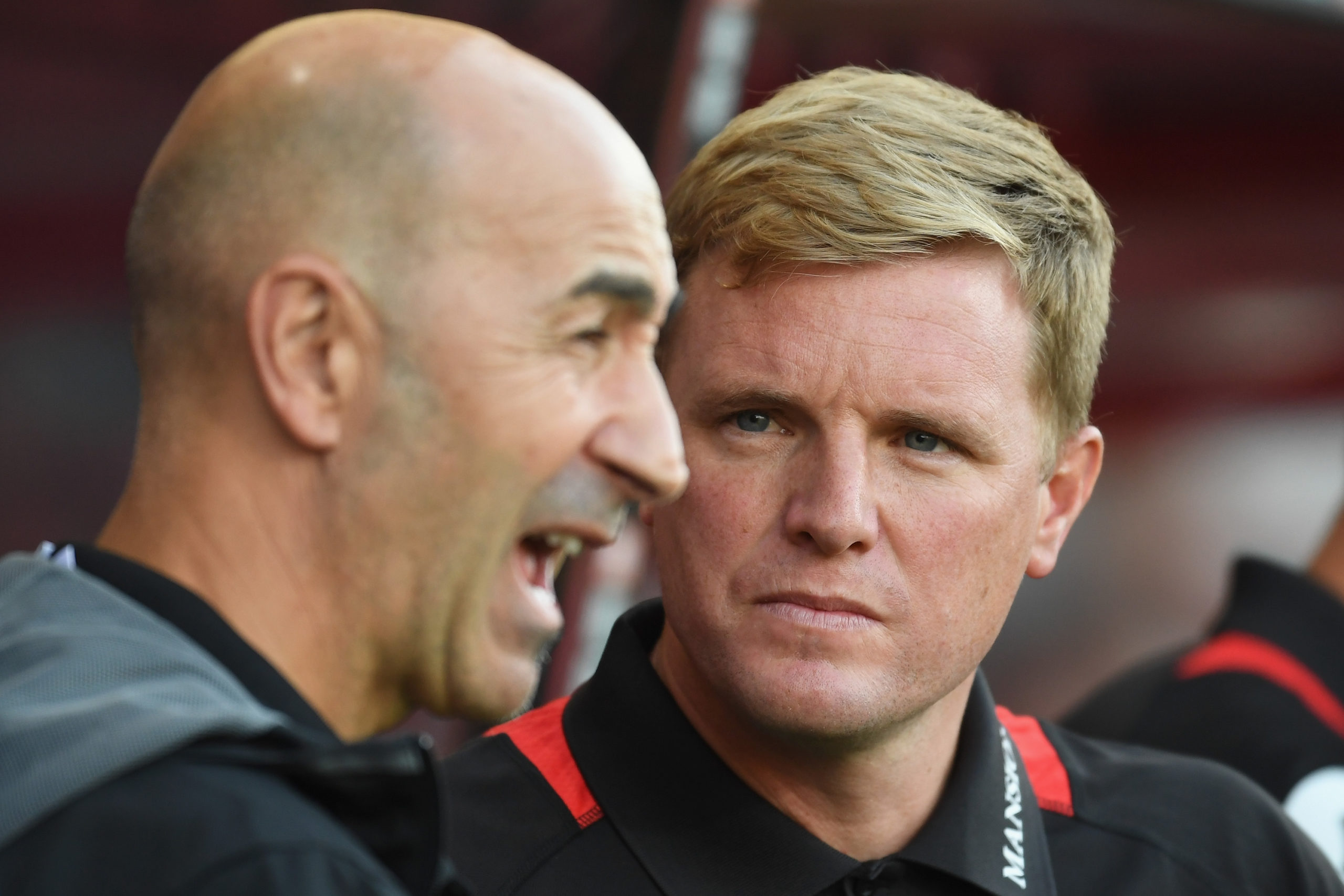 Bournemouth manager Eddie Howe listens intently to Valencia coach Pako Ayesteran.
