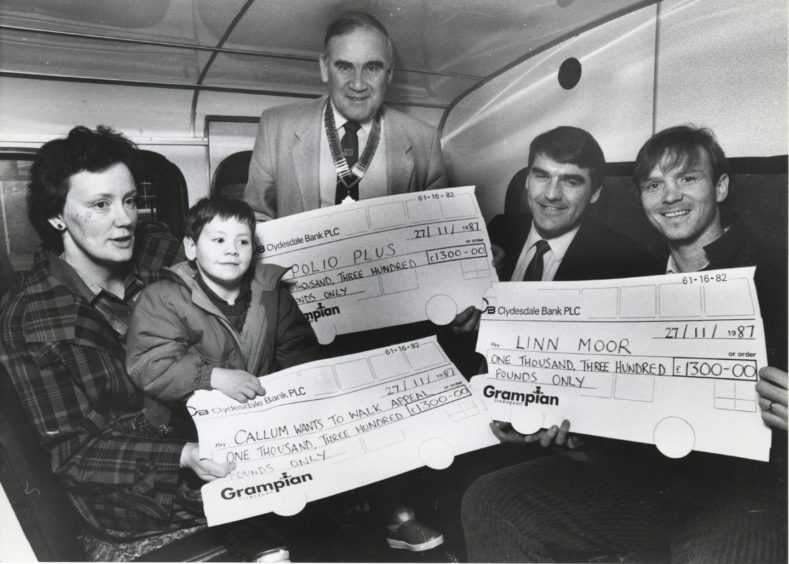 1987: Managing director of Grampian Transport Mr Moir Lockhead (second right) presents three cheques, each for £1300, from cash raised at Grampian Transport's recent 1st birthday party. Receiving them are (left to right): Mrs Linda McDougall and her son, Callum, Newtonhill, to help their Callum Wants to Walk appeal; Mr Jack Thain of Aberdeen Rotary Club, to boost the Rotarians' Polio Plus Campaign; and Alex McLeish, for the Linn Moor Appeal. The presentations took place at Grampian Transport's King Street depot.