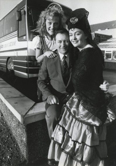 1988: Adding a continental flavour to the launch of the new holiday tours to be provided by Grampian Transport in conjunction with Tayside Transport and Mairs Coaches are Debby Gillespie and Leigh Coats with driver Mr Eddie Arthur.