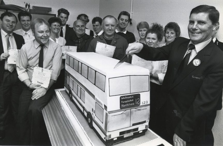 1989: Getting a slice of the cake is bus driver Mr Alexander Stuart, Summerhill, at a ceremony to mark the deal. The cake will today be given to Royal Aberdeen Children's Hospital.