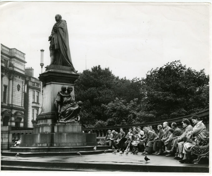 1957: People feed the pidgeons in front of the statue of King Edward VII on Union Street, Aberdeen, at the juntion with Union Terrace.