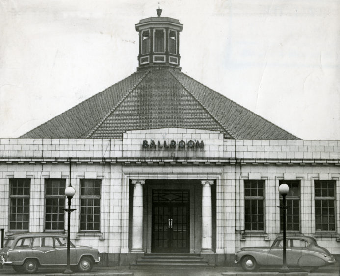 1958: The entrance to the Aberdeen Beach Ballroom with two cars parked in front.