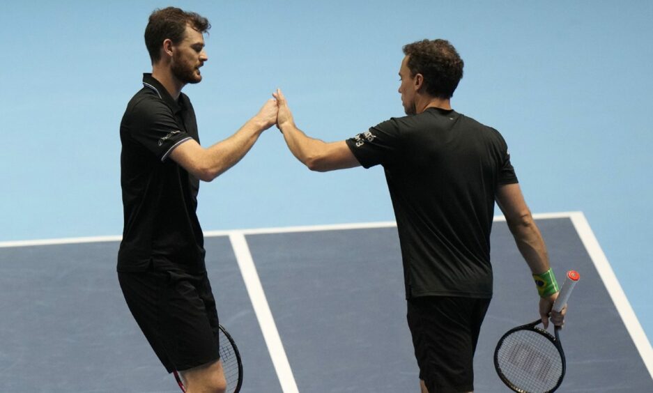 Jamie Murray high-fiving a colleague on the court