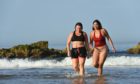 Zahra Abdul from Tarves (red) and Gemma Emslie from Aberdeen are pictured at Cullen beach, Moray on the hottest day of September in 100 years. Pictures by Jason Hedges.