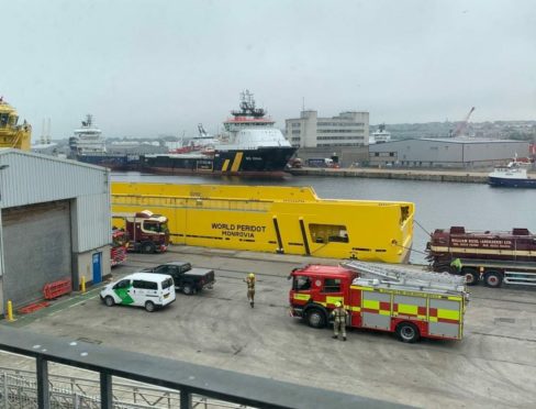 Firefighters are currently working to free a man from a confirmed space onboard an American offshore supply vessel.