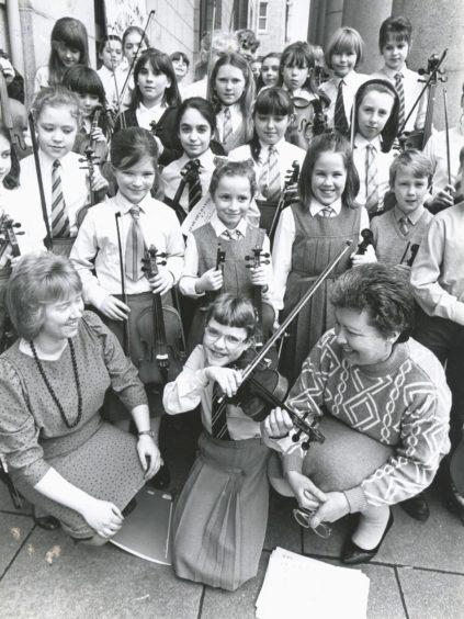 1989: Stringing along...Ten year old Rhona Donald (front centre), Westhill, with conductors Susan Simpson (left), Ellon, and Beverley Lithgow (right), Westhill, with other members of the Aberdeen Music Centre Beginners' String Orchestra who took part in a concert at Aberdeen Music Hall on Saturday.