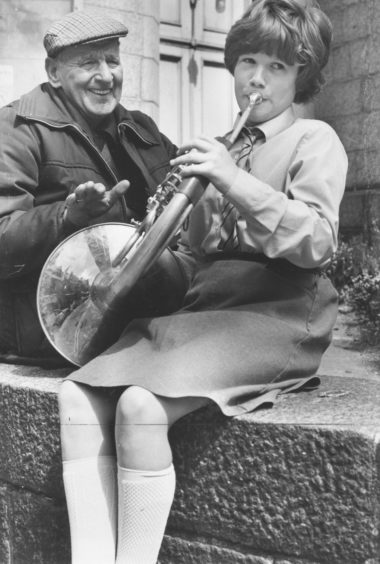 1984: Pensioner Alex England enjoys a tune from 10 year old Josephine Watson, of Gairn Terrace, Aberdeen, who won the French Horn 13 years and Under section.
