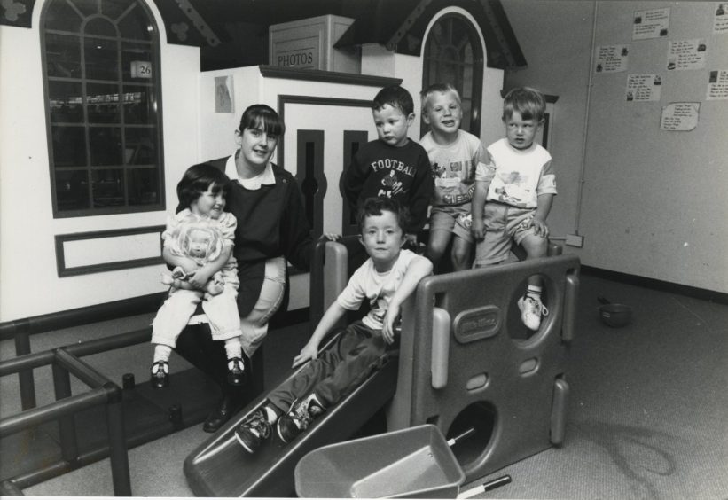 1992 - Norco’s play area supervisor Donna McLean joins in the fun with the children at the Berryden Road store