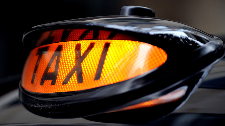 A taxi light on a black cab. 