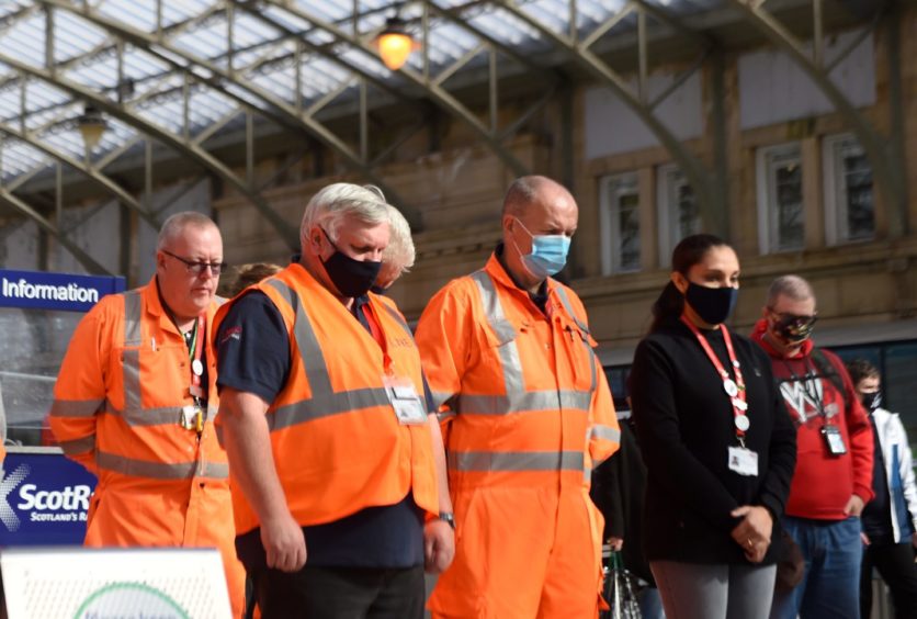 Workmen and staff at Aberdeen station observe the one minute's silence. 