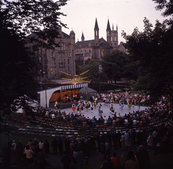 Over the years UTG has played host to a wide variety of entertainment and festivals. This image shows a well-attended evening performance of country dancing during the late 1970s. The Belmont Cinema and Belmont Congregational Church are visible in the background.