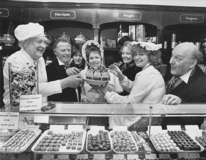 1987: The Pro-Arte Singers, who are staging Waltzes from Vienna in Aberdeen Arts Centre from April 28, decided that to get the right feel for the opening scene set in a confectionary shop/café in Vienna, they should sample some of the delights on offer in Nova, Rose Street. There, chocolate shop girl Linda Smith (centre) decided that the cast (left to right) Eric Coutts, Ian Middler, Sue Chalmers, Marjory Robb, Hilary Esson and Stewart Smith thought everything would be just a piece of cake!