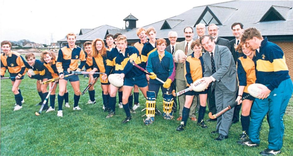 Headmaster George Allan joins hockey and rugby players ready to try out the new £3 million sports field development at Countesswells