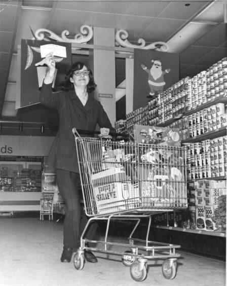 1971:  Mrs Elvira Hay, 21 Catto Crescent, Cove Bay, who won £250 in the Fix-the-Bail competition on a Green Final coupon and a shopping spree at Fine Fare supermarket, Bridge of Dee, races through the store with her haul and her £250 cheque.