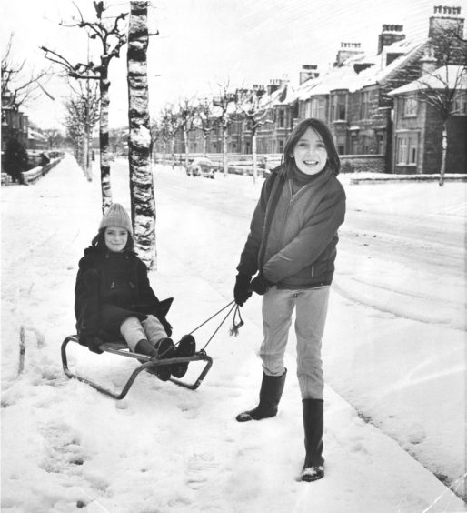 1976: Eleven-year-old Claire Darling, 70 Gladstone Place, Aberdeen, pulling her sister Caroline (12) along Forest Avenue on their sledge.