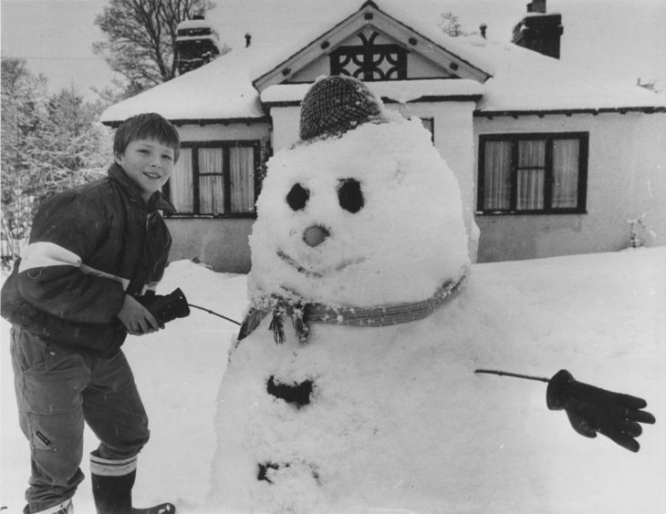 1985: Two faces of winter in the North-east yesterday captured by photographer Graham Robertson. For youngster Richard Merchant (above), the snow could only be put to good use and what a fine fellow of a snowman he has built. Richard (10), 47 Station Road, Banchory, shakes on it with his snowman.