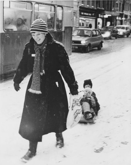 1985: The fastest way to the sales in Aberdeen this morning way by sledge Mrs Sue Lessels, of Whitehall Terrace, and her children, Tom (3) and Ellie (6) have the snails pace traffic beaten as they make their way down Union Street.