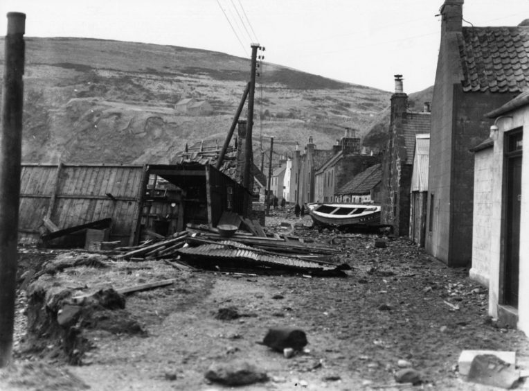 1953: A fishing boat lies in the middle of the street at Pennan in Banffshire after the great gale of January 1953. Many of the houses in the village were severely damaged by the winds.
