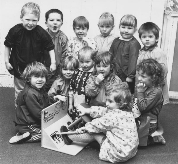 1987: Dawn Adams puts her car into gear but it looks like some of her nursery class friends are a bit doubtful about her driving skills!