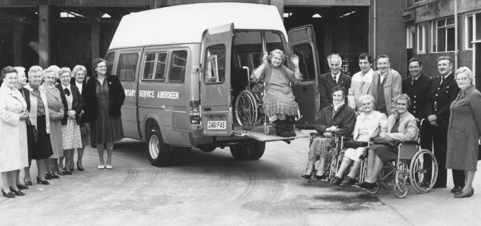 1987: Among the first to benefit from the windfall was Mrs Isabella Wiseman (83), in the new Christopher Car bought by VSA. On the right are members of the Grampian Fire Service, who drive the van, Sandy Corbett, Richard Kelbie, Eddie Rose, Archie Spence with organiser Mrs Margaret Grant and some of their customers. Some of the helpers are pictured on the left.