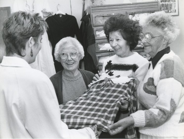 1991: Showing a customer a garment in the Castle Street Thrift Shop are, Mrs Gladys Reid , Mrs Joyce Clark and Mrs Madge Young.