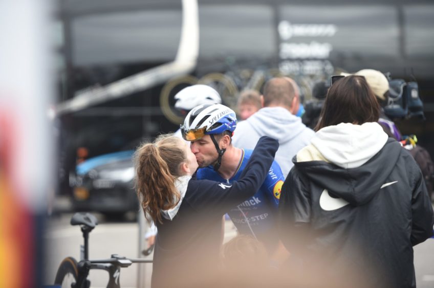 Mark Cavendish signing autographs and being wished good luck by his daughter.