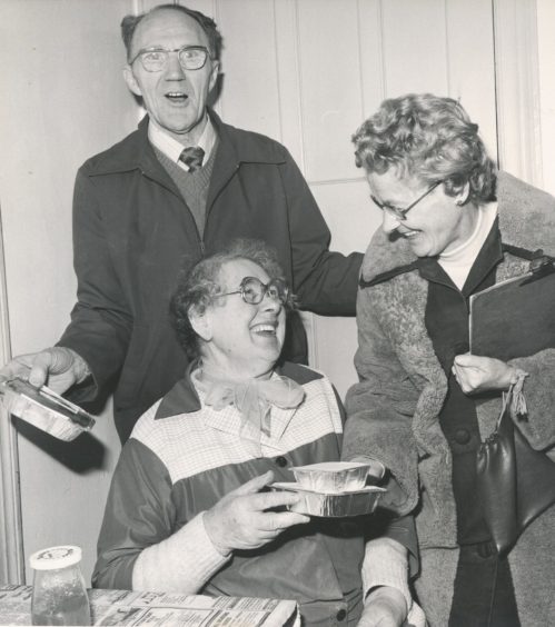 1981: Mrs Isabella Brown, Aberdeen (seated), receives her meals on wheels from Mrs Helena Rattray and her husband Francis, Gilcomstoun Land, Aberdeen.