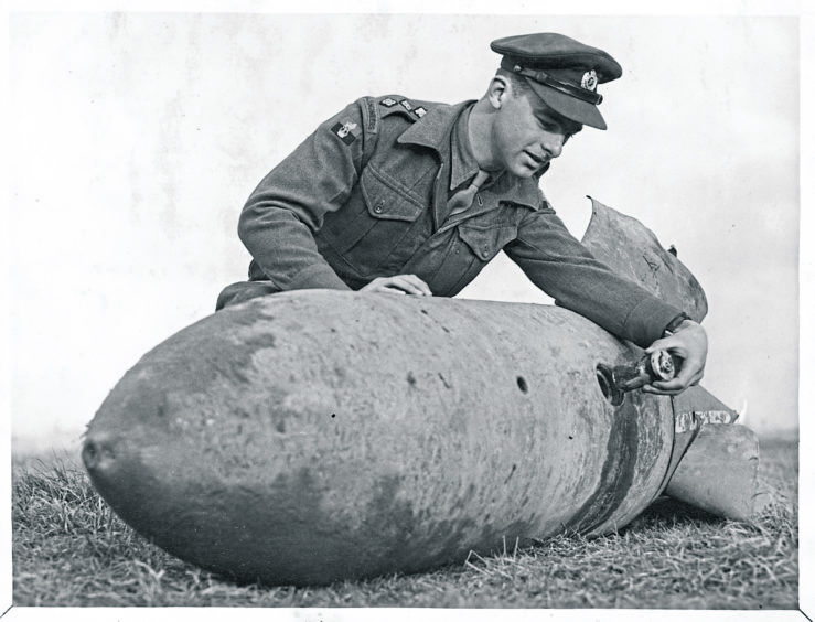 1949: Capt. P.S. Wadsworth shows the fuse pocket from which he extracted yesterday the fuse in a live bomb that lay for eight years in the ground near Fraserburgh Maternity Hospital. Picture taken 21 November 1949.