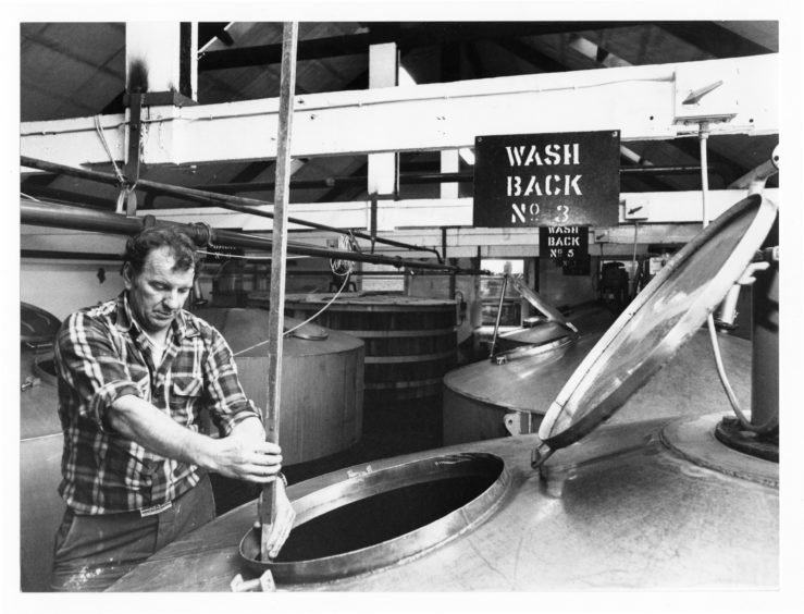 1979: Mashman Bob Clark dry dips a wash back to check on levels at Glen Garioch Distillery