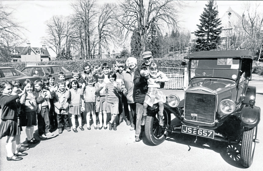 The cavalcade of cars from the newly-opened Fyvie Castle to Castle Fraser to open the Castle Trail stopped at Kemnay School to meet the pupils in May 1986. Pictured with their Model T Ford are Nairn couple Alan and Dorothy Grant with Bridget Graves, 6, and some of the children