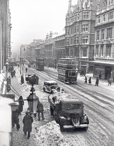 1942: Snow is cleared off the pavements opposite the Esslemont & Macintosh store