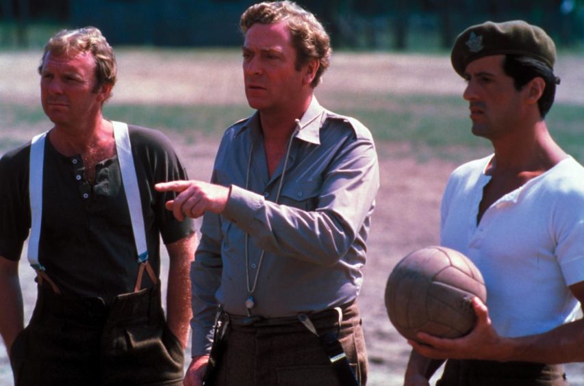 Bobby Moore, Michael Caine and Sylvester Stallone film scenes in the POW camp during shooting of the movie in Budapest in 1980.