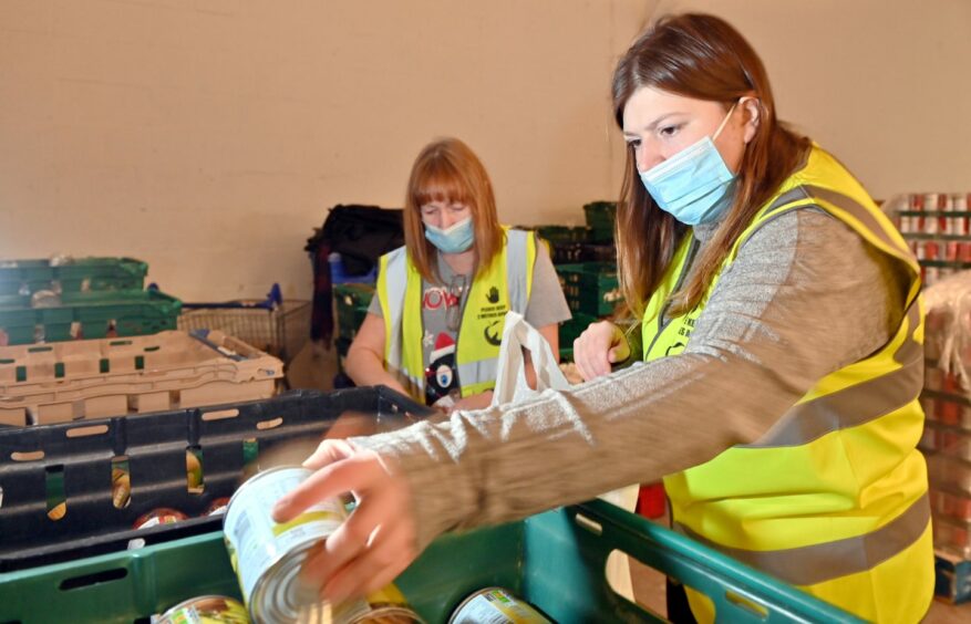 Lauren Taylor with another Cfine volunteer, filling food parcels. 