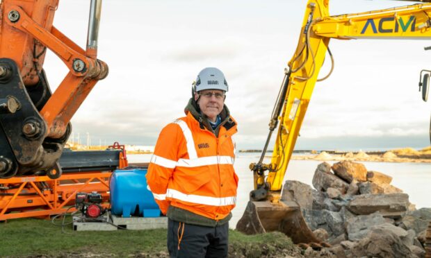 Andy Limbert, project manager of new Lossiemouth bridge, with construction underway behind.