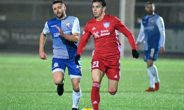 Peterhead midfielder Grant Savoury on the ball with Montrose's Mark Whatley in pursuit