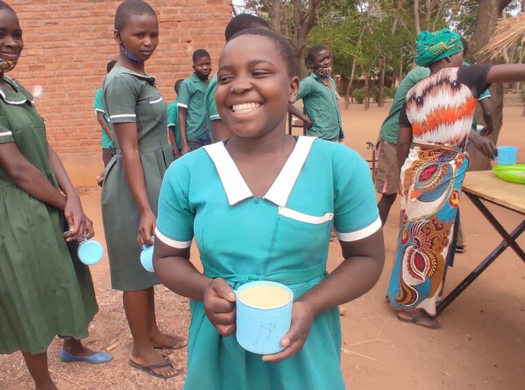 A smiling girl in a blue-green dress 