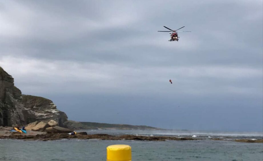 A Coastguard helicopter hovering over rocks where Zander Craib was located. 