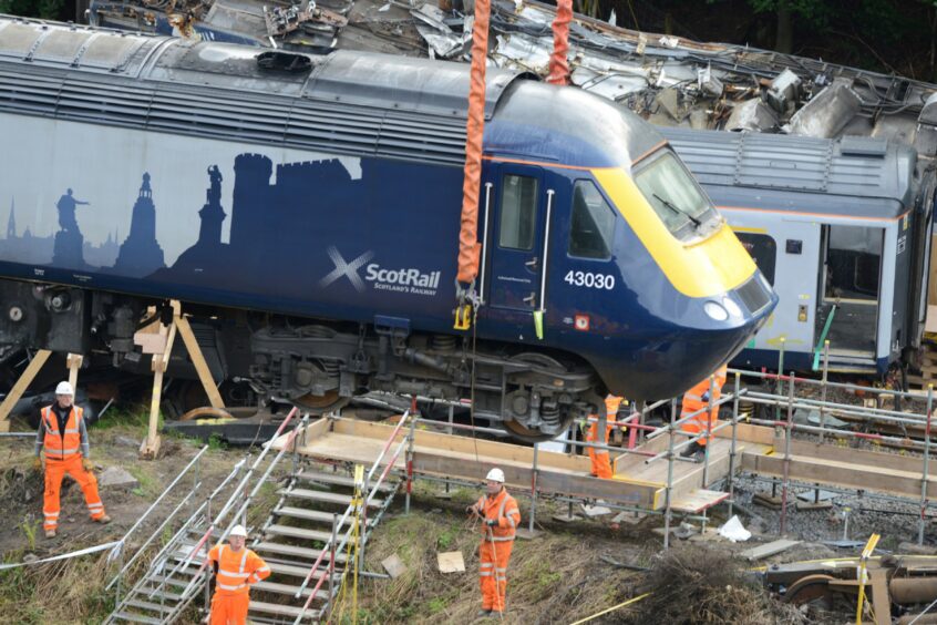The first train carriage is recovered after the Stonehaven rail crash.
