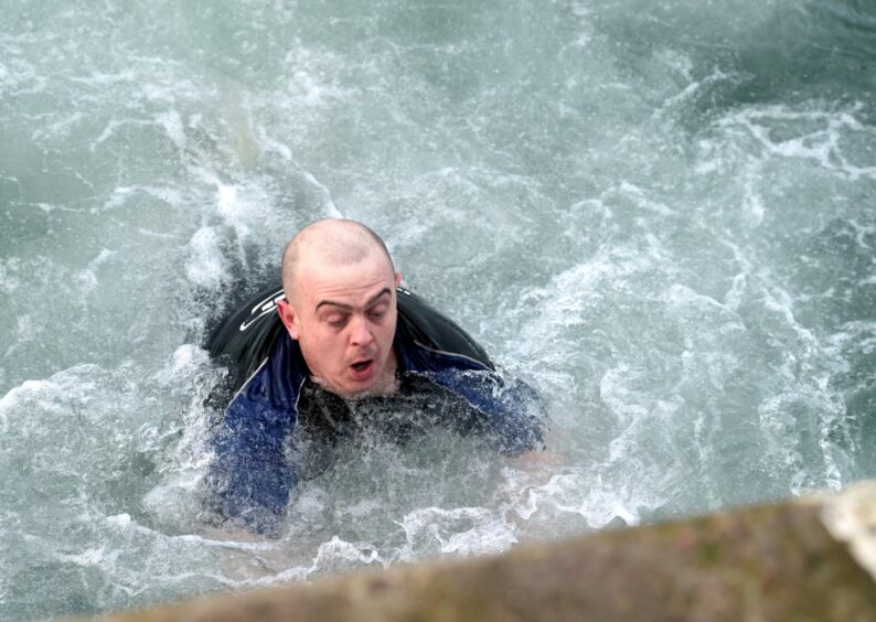 Swimmers braved the chilly Moray Firth water to swim across the harbour entrance. Photo: Sandy McCook/DCT Media