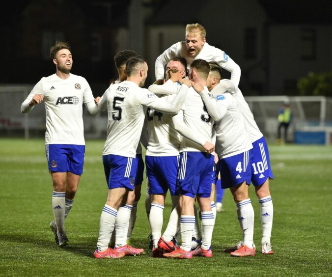 Fraser Fyvie is mobbed by Cove Rangers team-mates after scoring the opener