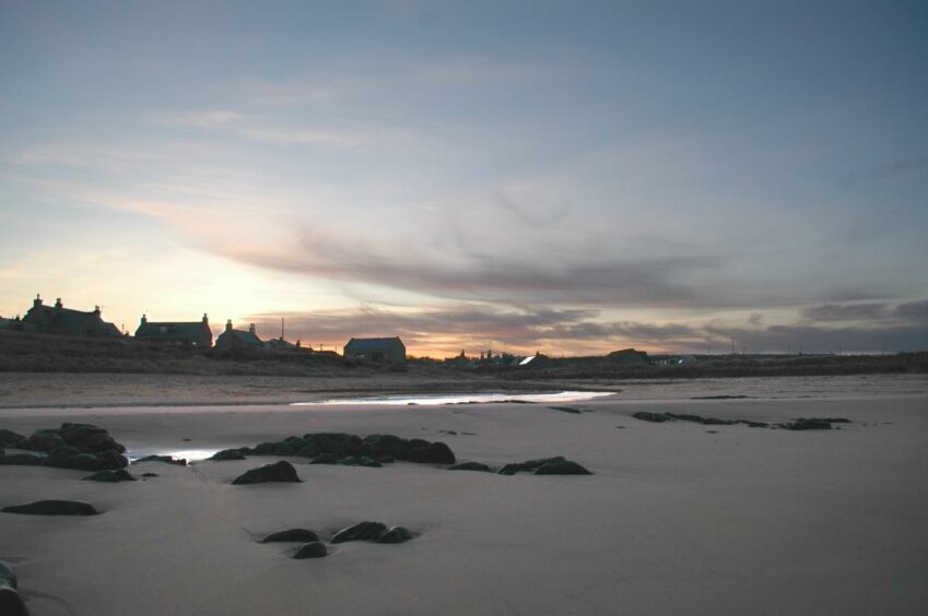 Cottages at sunset by the sandy beach at St Combs near Fraserburgh.