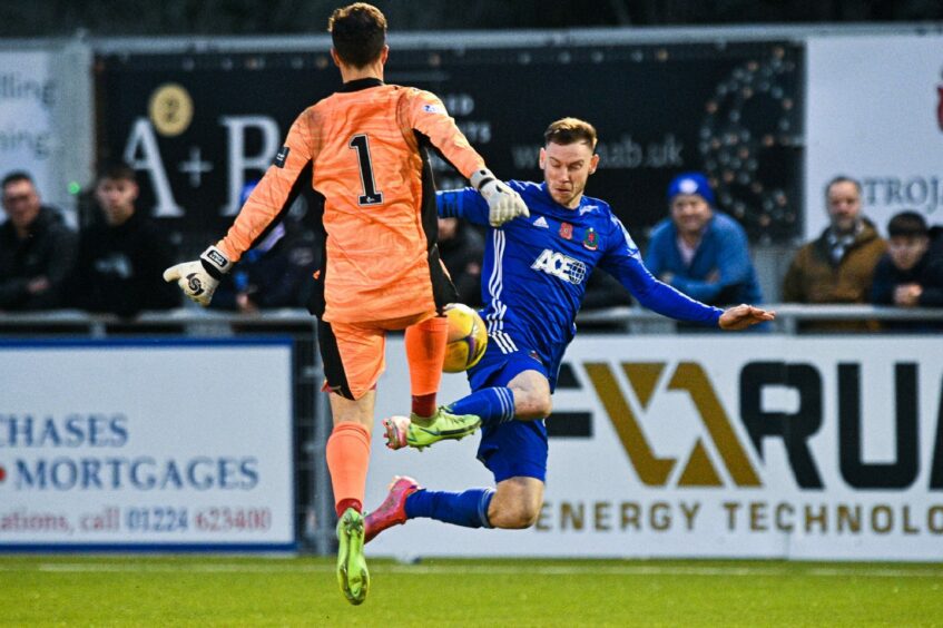 Brett Long challenges Cove Rangers striker Mitch Megginson