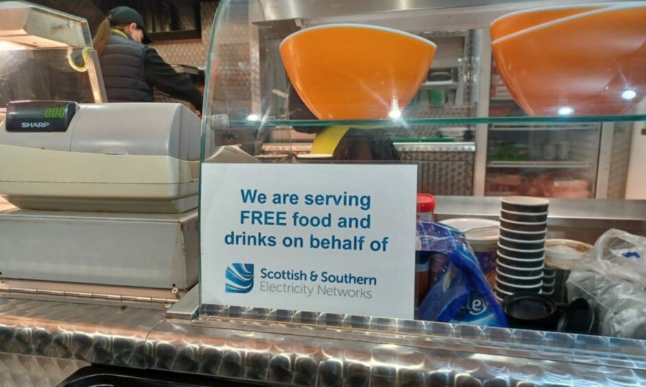 A SSEN sign at a catering van showing "We are serving free food and drinks on behalf of SSEN"