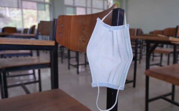 A face mask on a chair in an empty school classroom