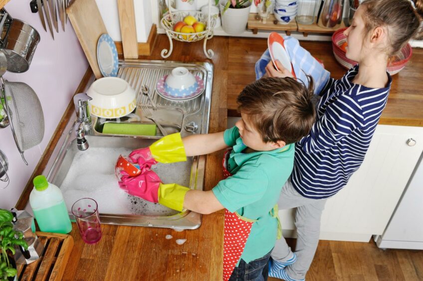 two kids doing the dishes to get pocket money