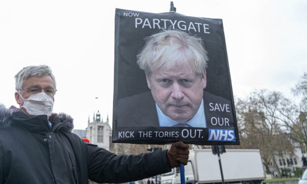 A protester demonstrates against Boris Johnson after allegations of Downing Street Christmas parties during 2020 (Photo: Amer Ghazzal/Shutterstock)
